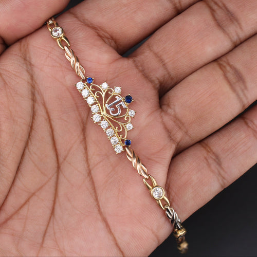 Gold bracelet with decorative elements held in a hand against a dark background