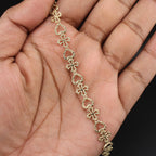 Gold bracelet on a hand with a dark background